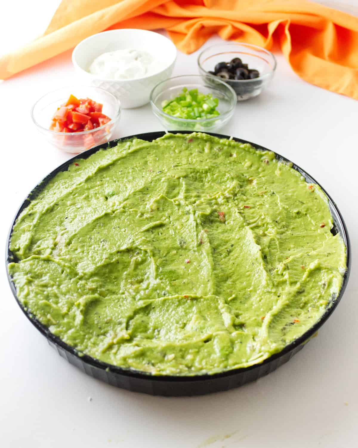 avocado mash, spread out in a dish.