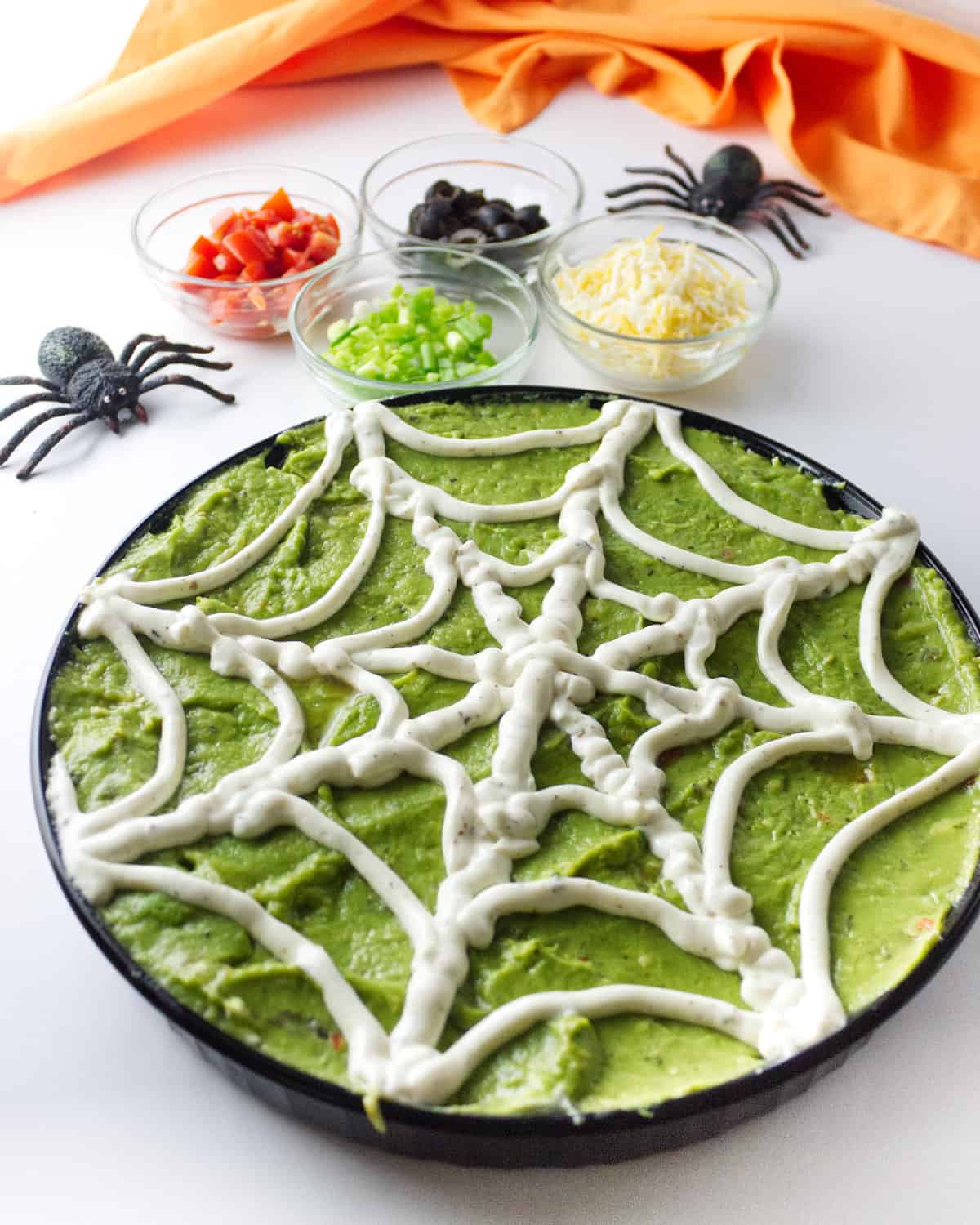 sour cream piped to look like a spider web in a dish.
