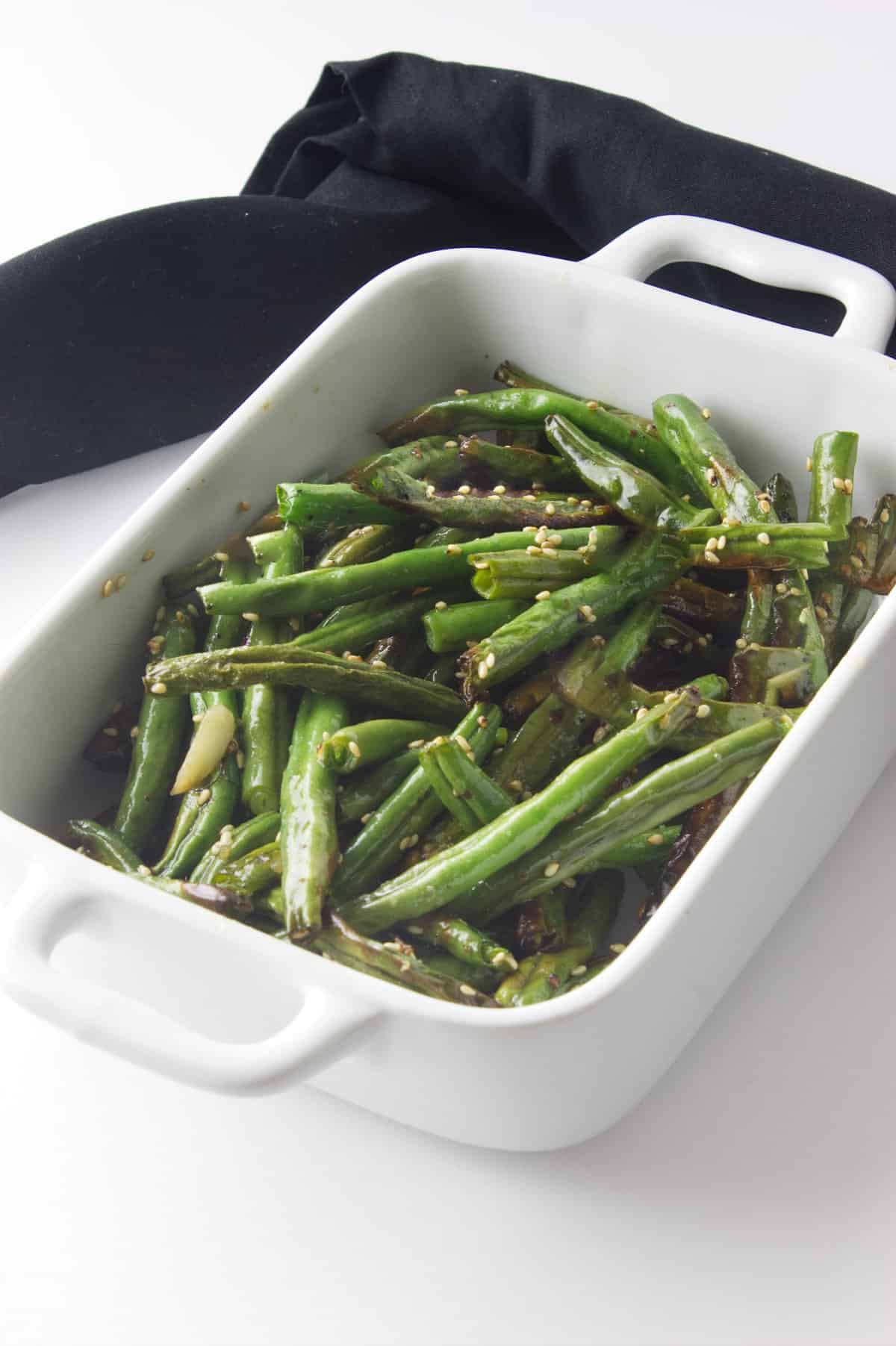 air fry frozen green beans seasoned with sesame oil and sesame seeds as garnish.