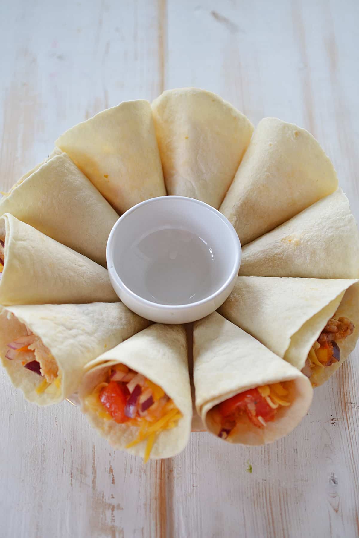 blooming quesadilla ring cones around a plate with bowl in center.
