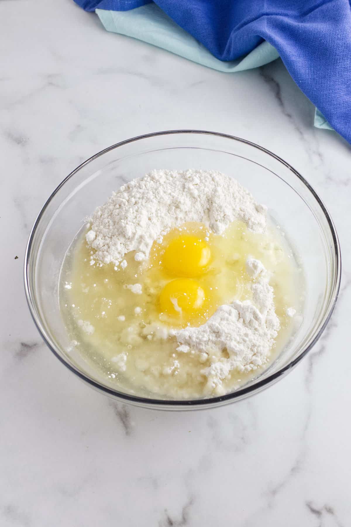 eggs and oil on top of dry cake mix in a bowl.