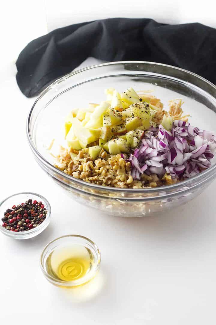 chopped apples, onion, and chicken in a bowl.