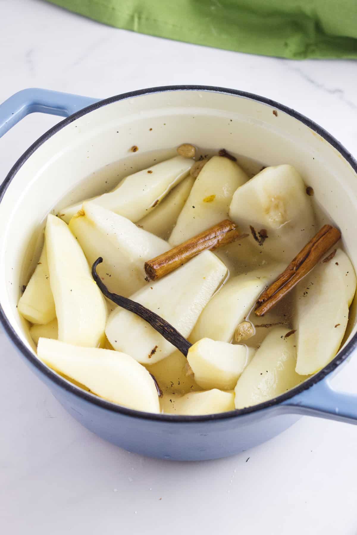 spices added to a pot of pears.