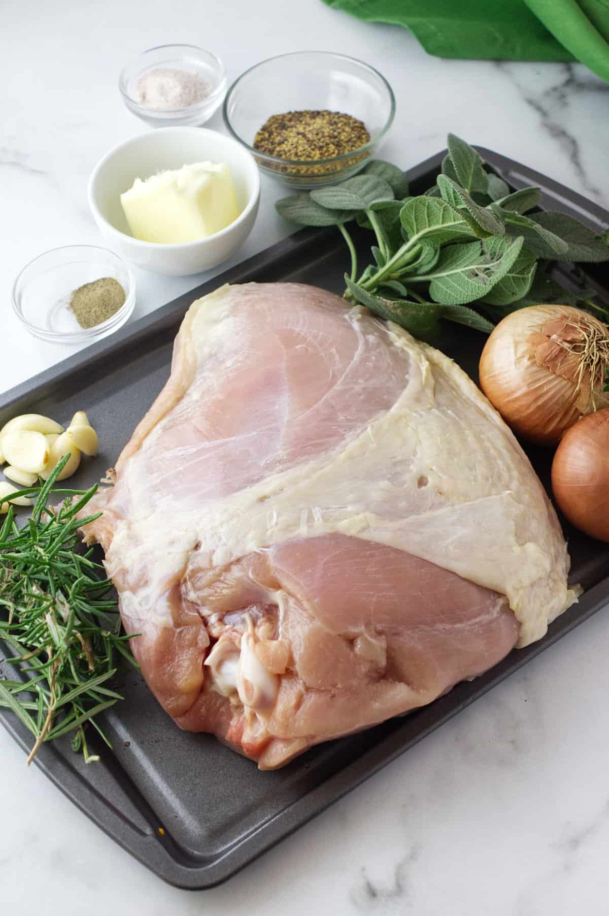 raw split turkey breast with herbs and spices.