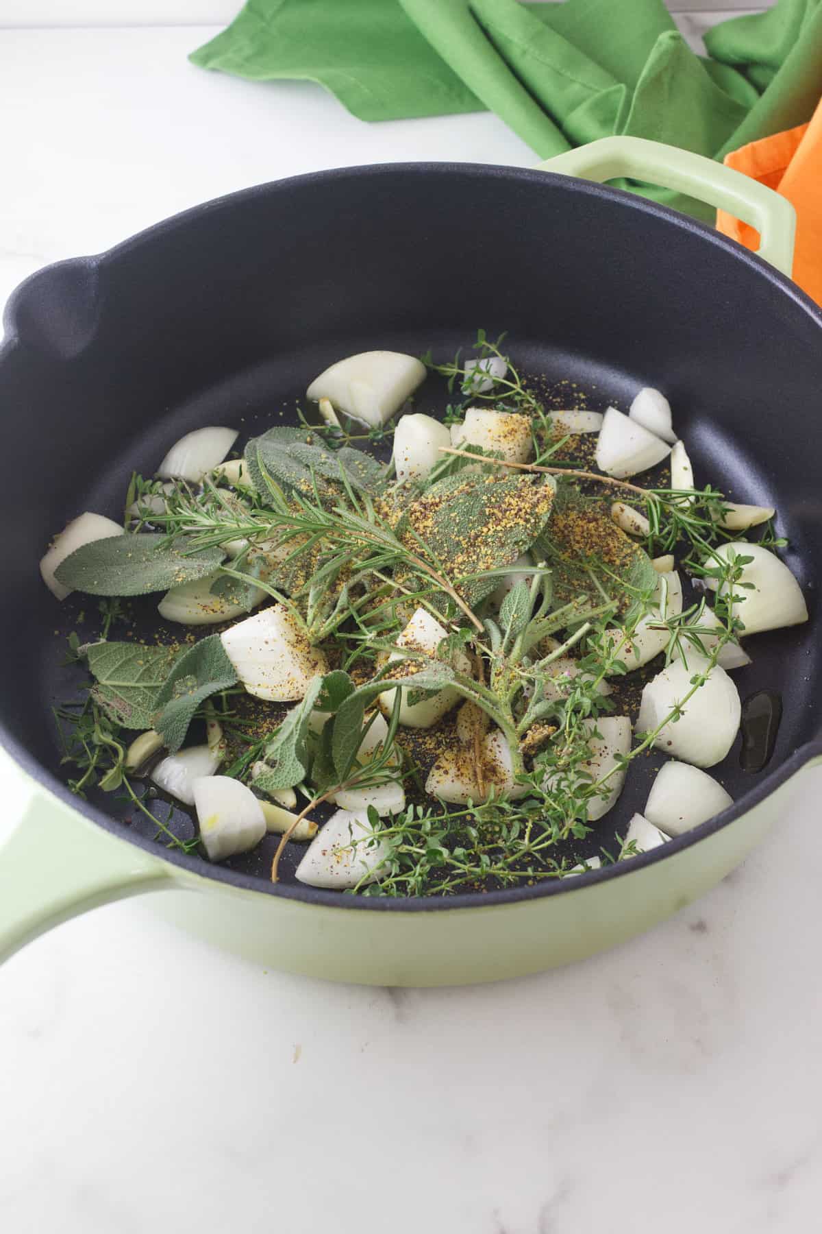 herbs and vegetables on bottom of dutch oven.