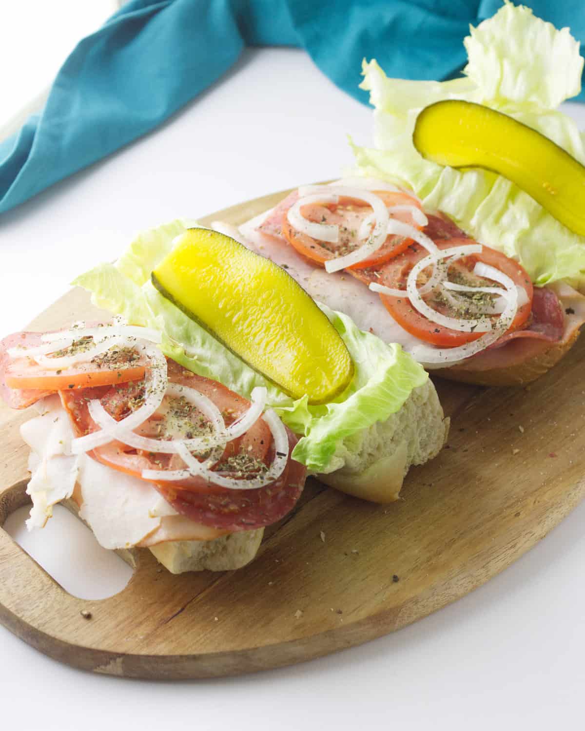 lettuce, pickle, onion topping meats on a hoagie.