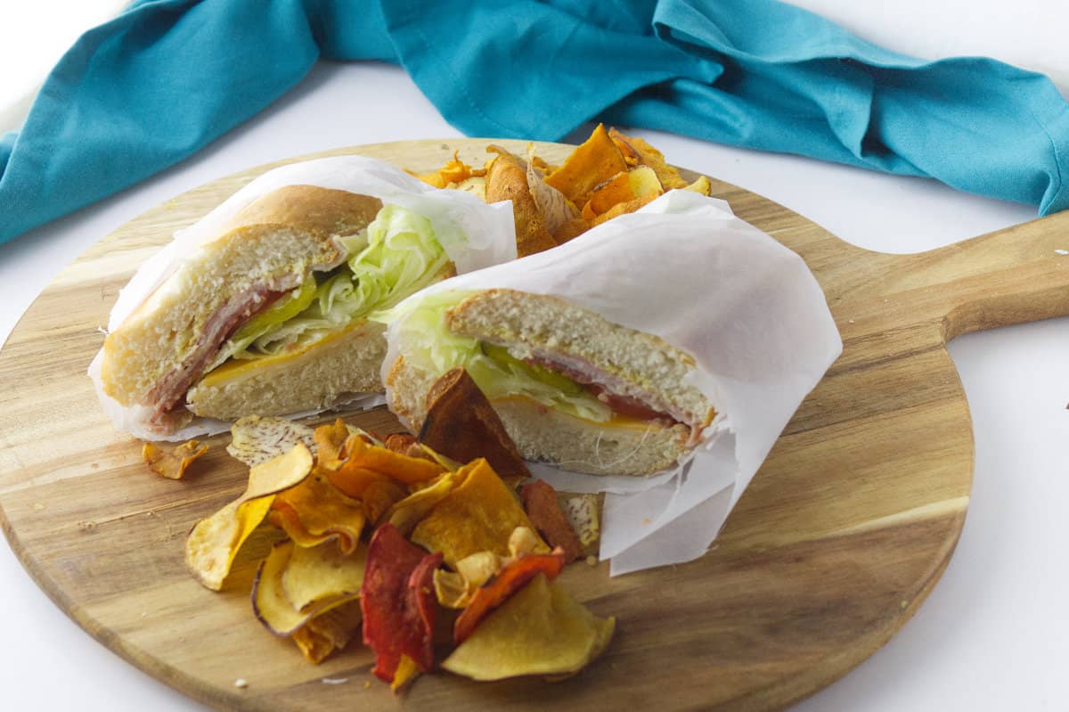 wraped grinder sandwich with potato chips.
