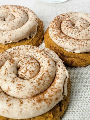big spice cookies with swirled frosting on top.