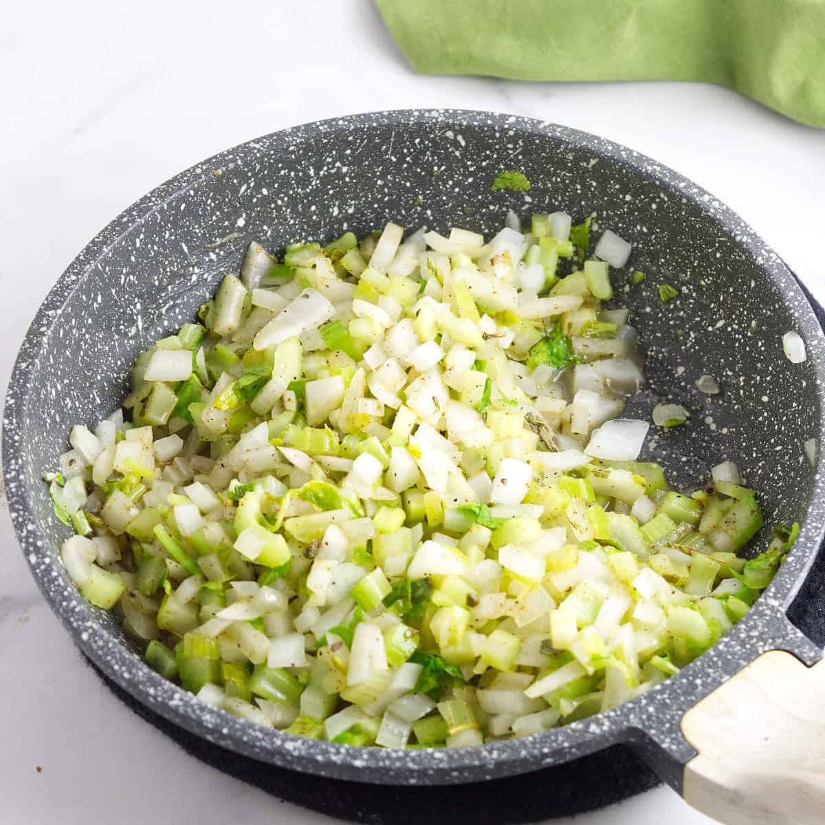 sauteed onions and celery in a saucepan.