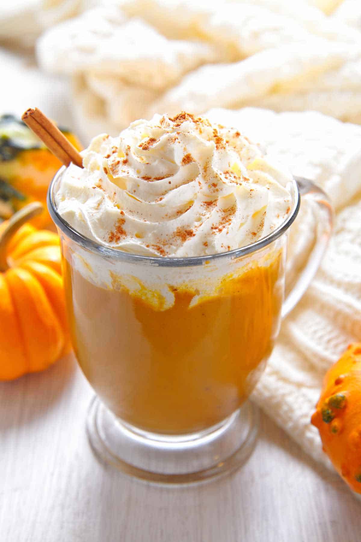 Pumpkin spice chai latte in a mug with whipped cream.