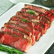 sliced ribeye steak on a platter.