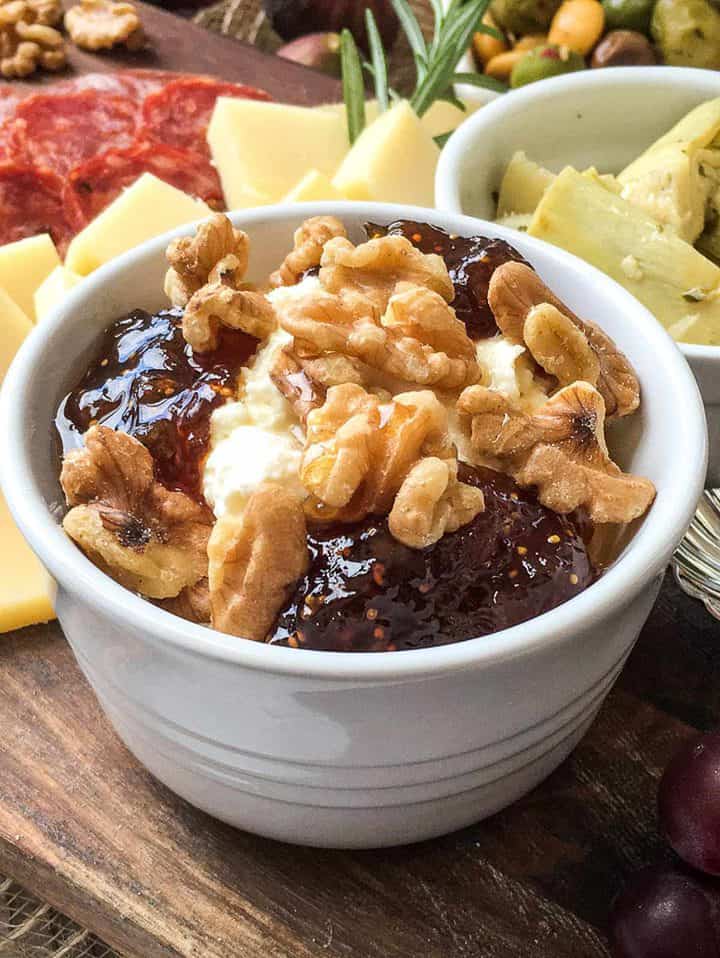 goat cheese and fig jam with walnuts in a serving bowl for meat and cheese board.