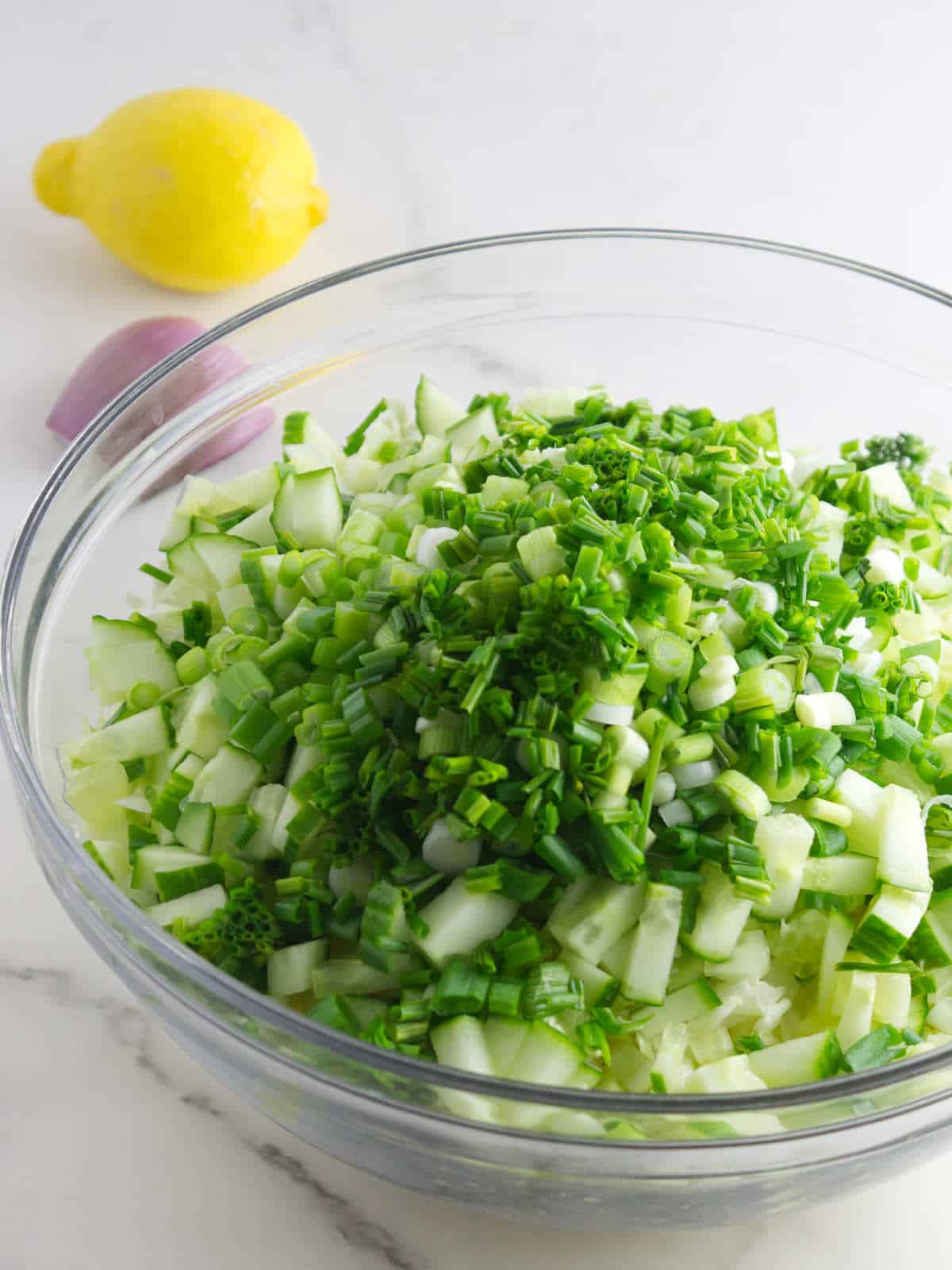 chopped green onions and chives on top of chopped cabbage.