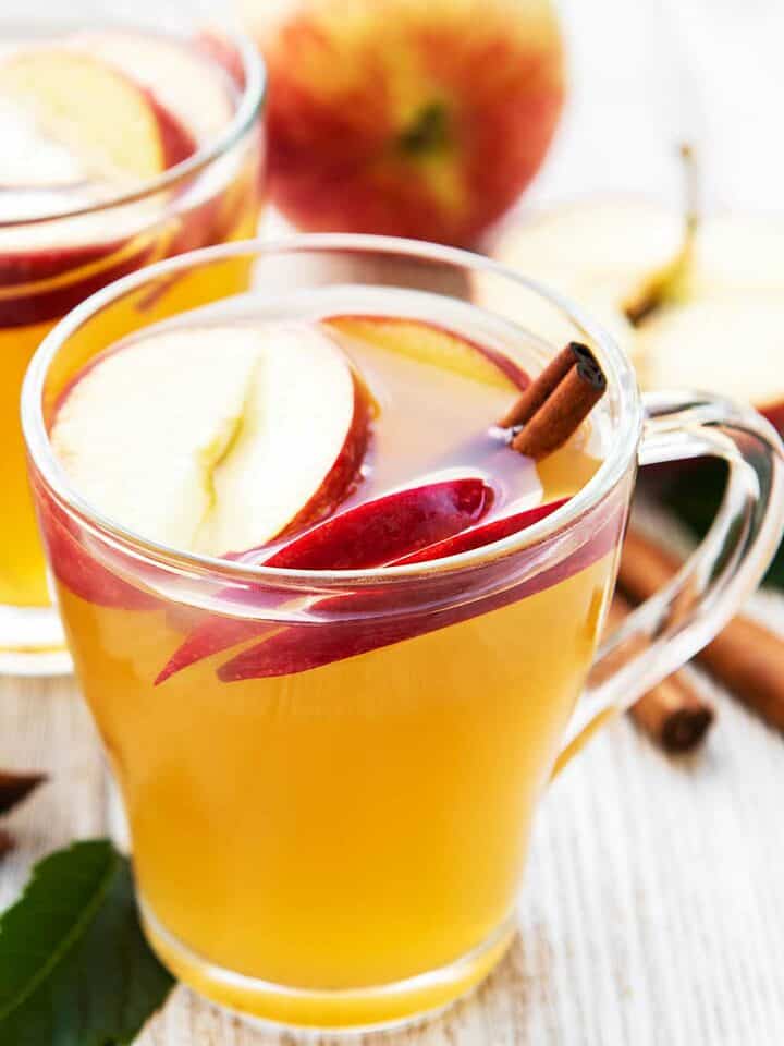 Apple cocktail with sliced apple & cinnamon sticks.