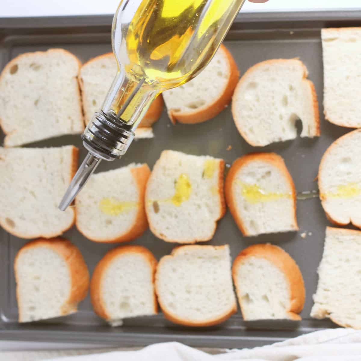 olive oil drizzled on french bread for toasting.