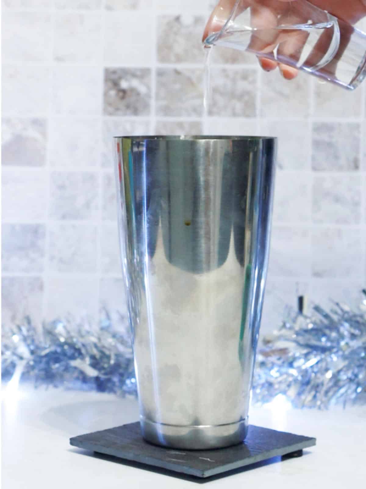 adding creme de cocoa to a cocktail shaker.