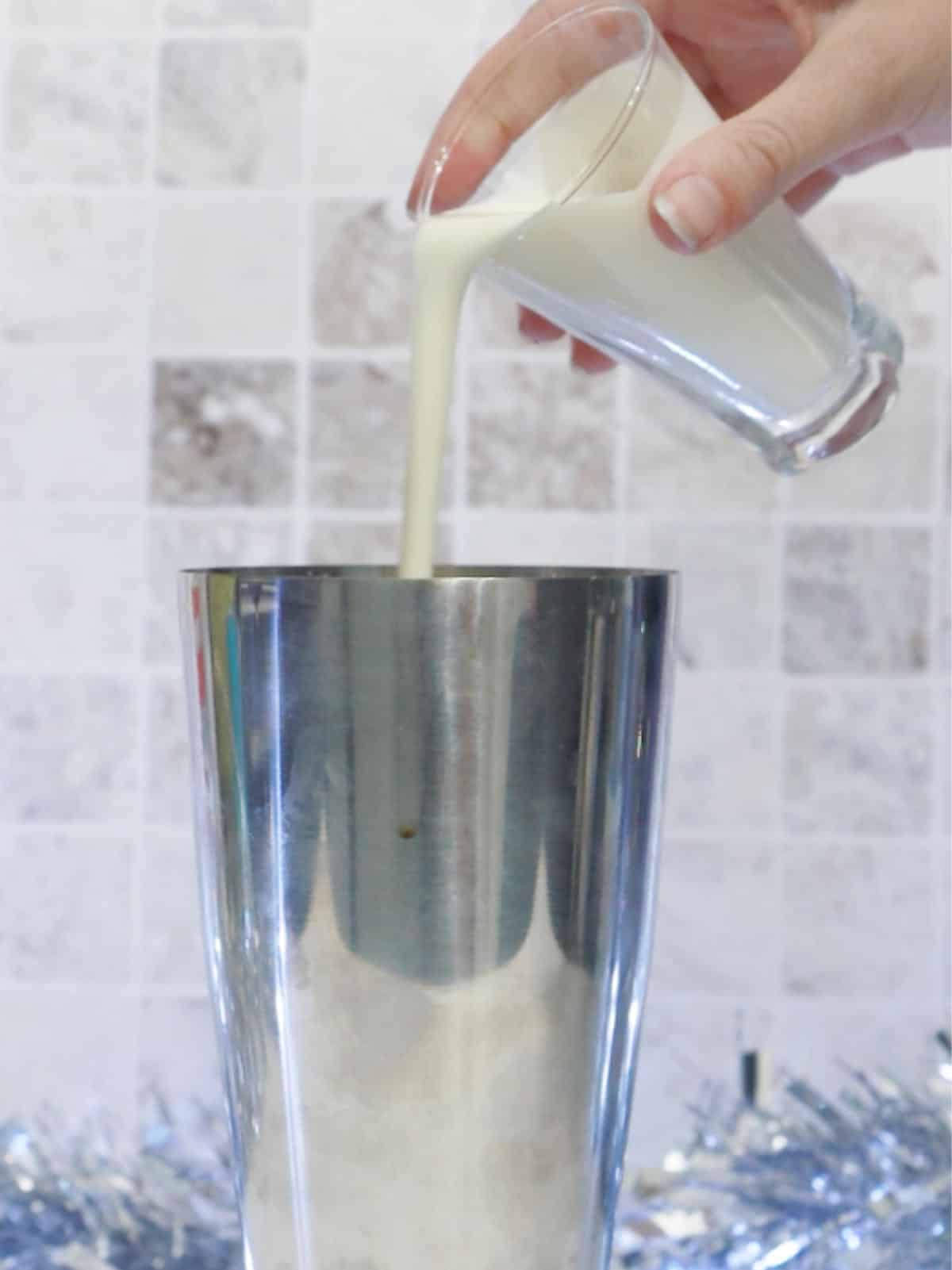 Adding cream to a cocktail shaker.