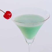 Creme de menthe grasshopper cocktail with a maraschino cherry garnish.
