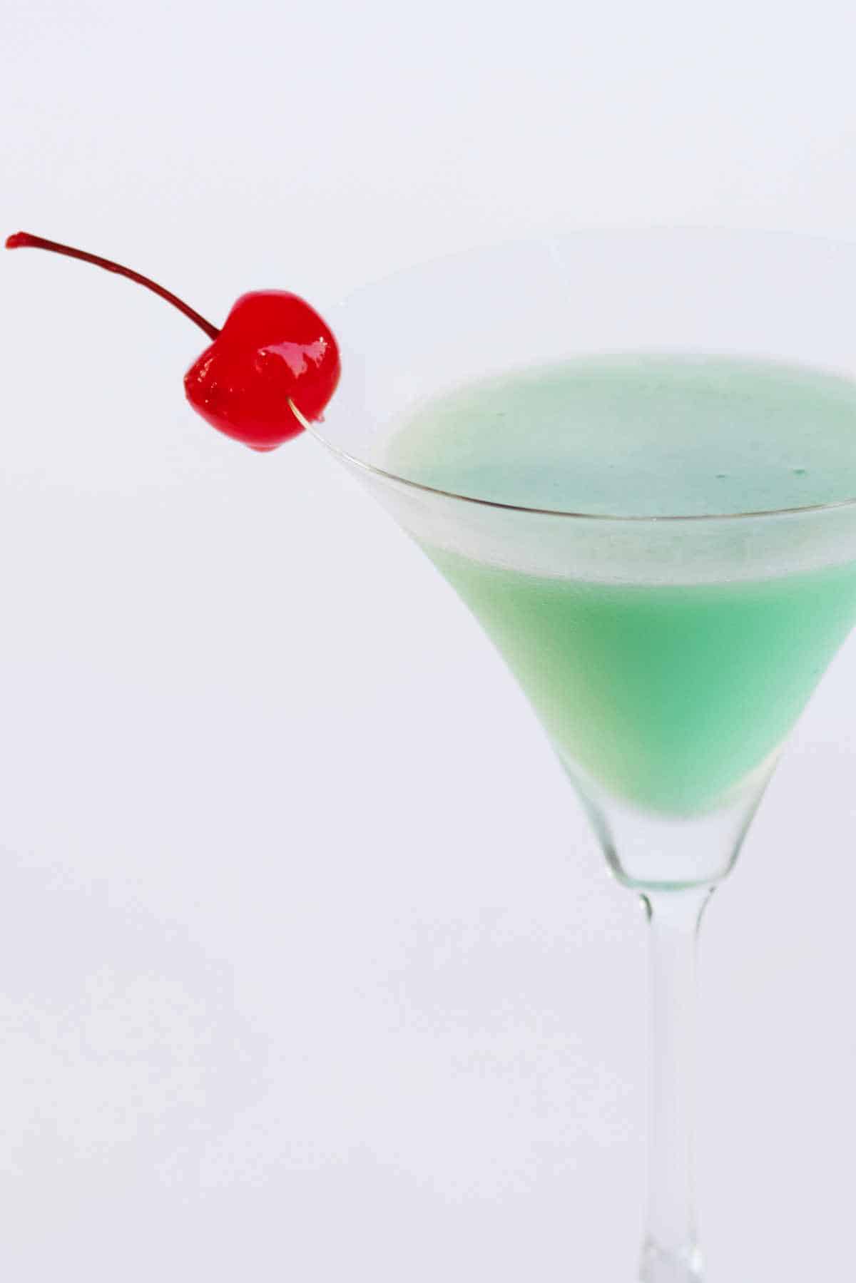 Creme de menthe grasshopper martini with a maraschino cherry garnish.
