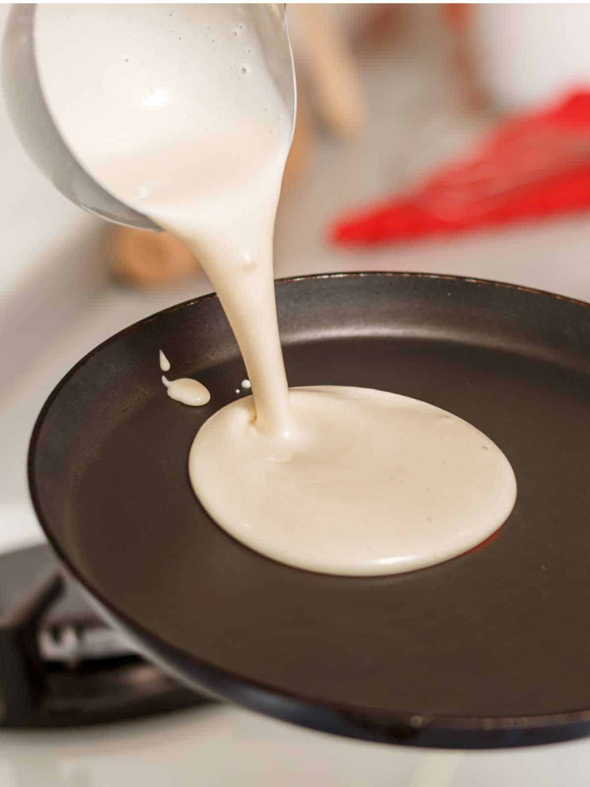 pouring some pancake batter onto a hot griddle.