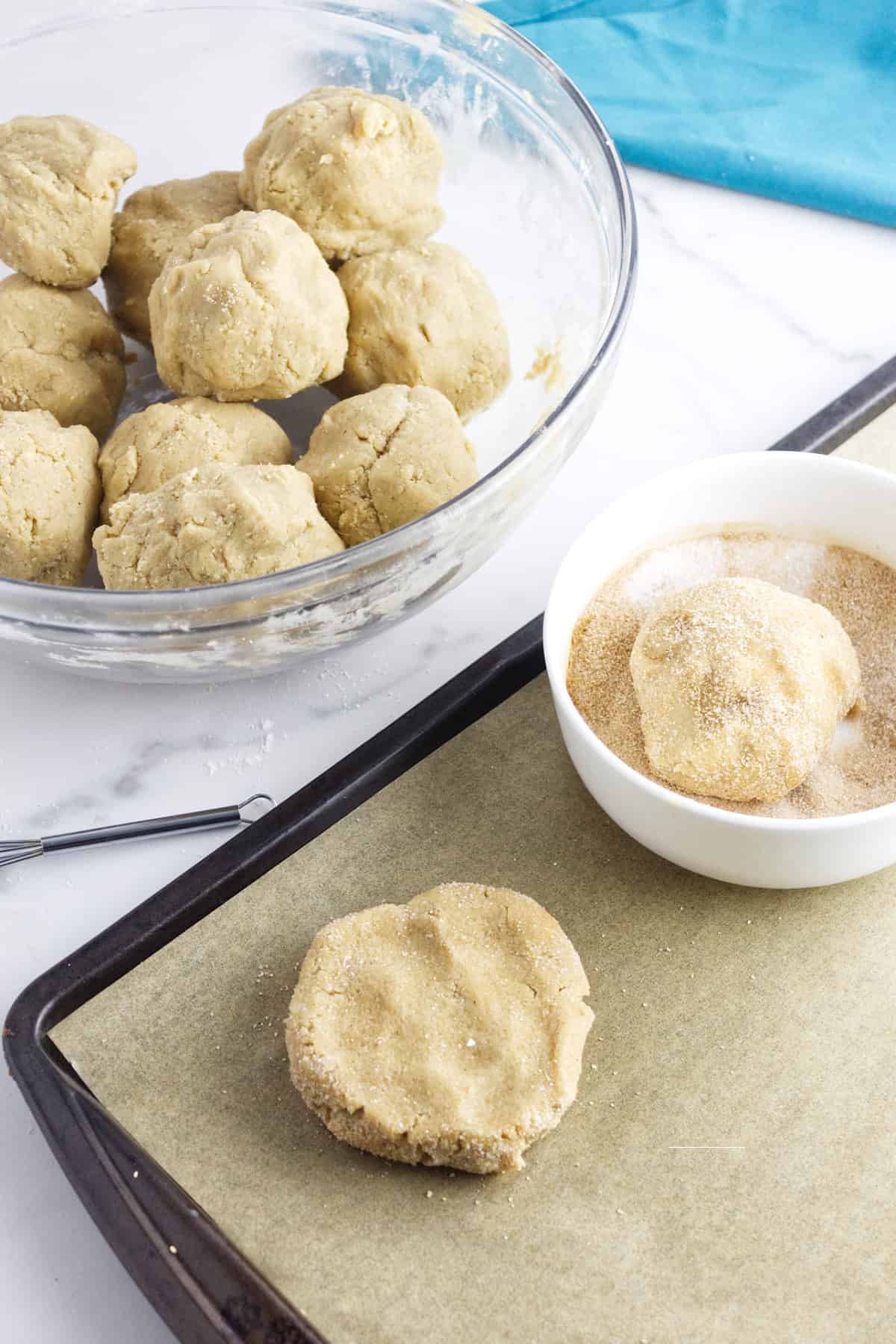 balls of cookie dough rolled in cinnamon sugar for crumbl churro cookie.