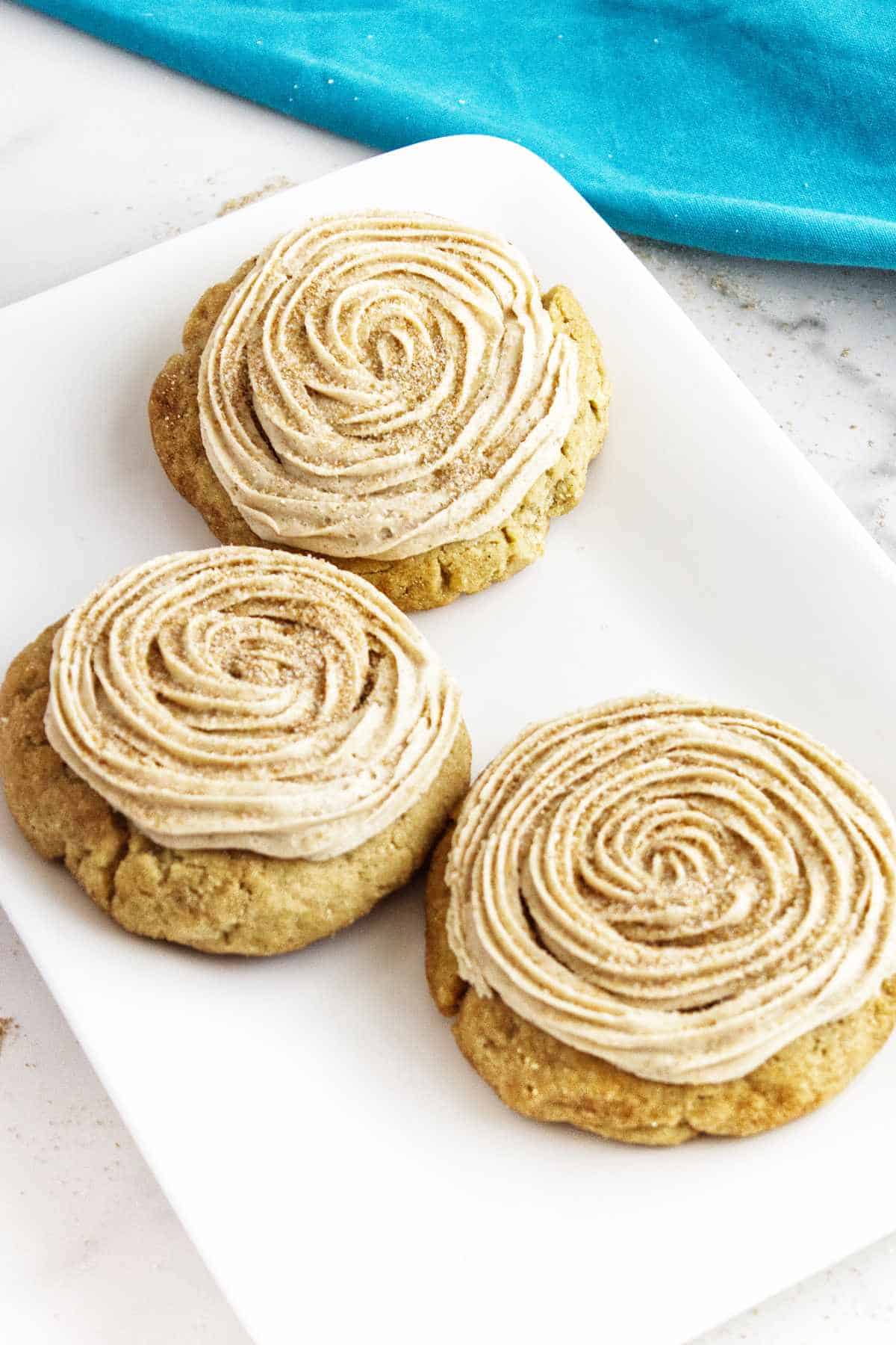swirl frosted crumbl churro cookie on a rack.