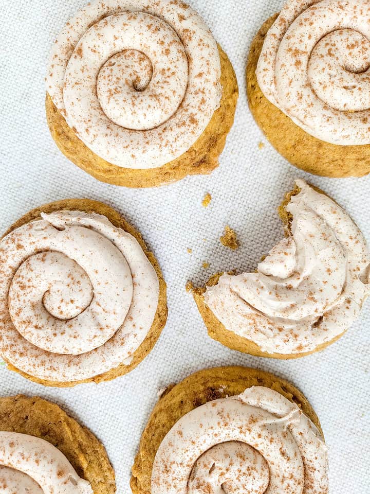 soft pumpkin spice sugar cookies with swirls of frosting on top.