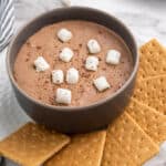 bowl of chocolate dip with mini marshmallows and graham crackers.