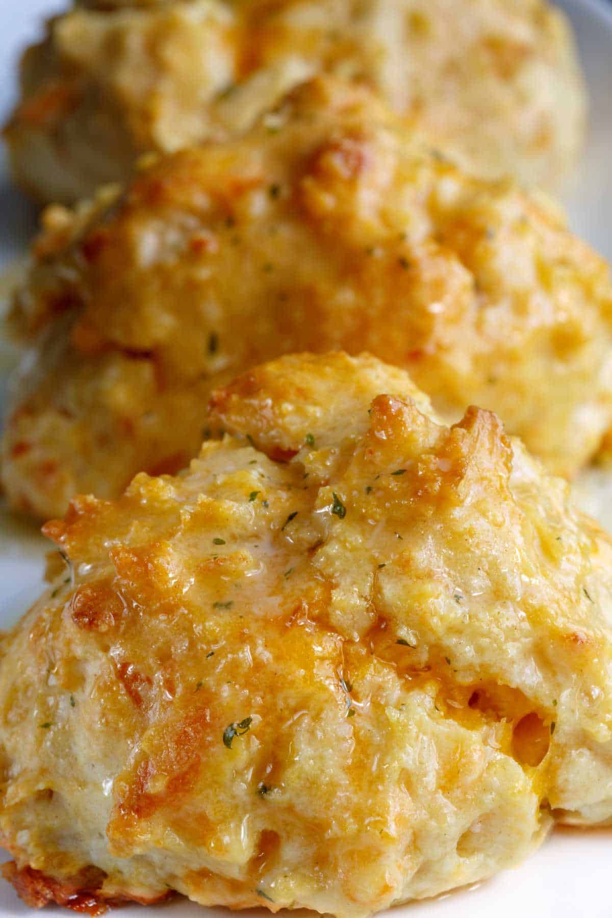 row of cheddar cheese keto biscuits on a plate.