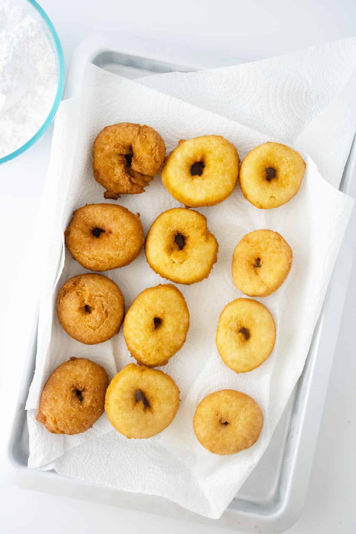 donuts cooling on paper towels.