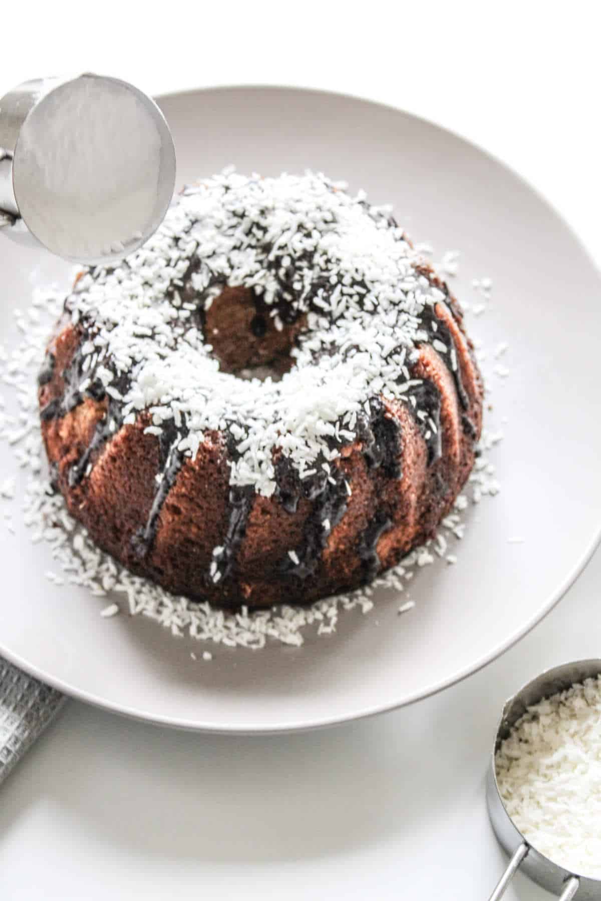 coconut sprinkled on top of a chocolate frosted cake.