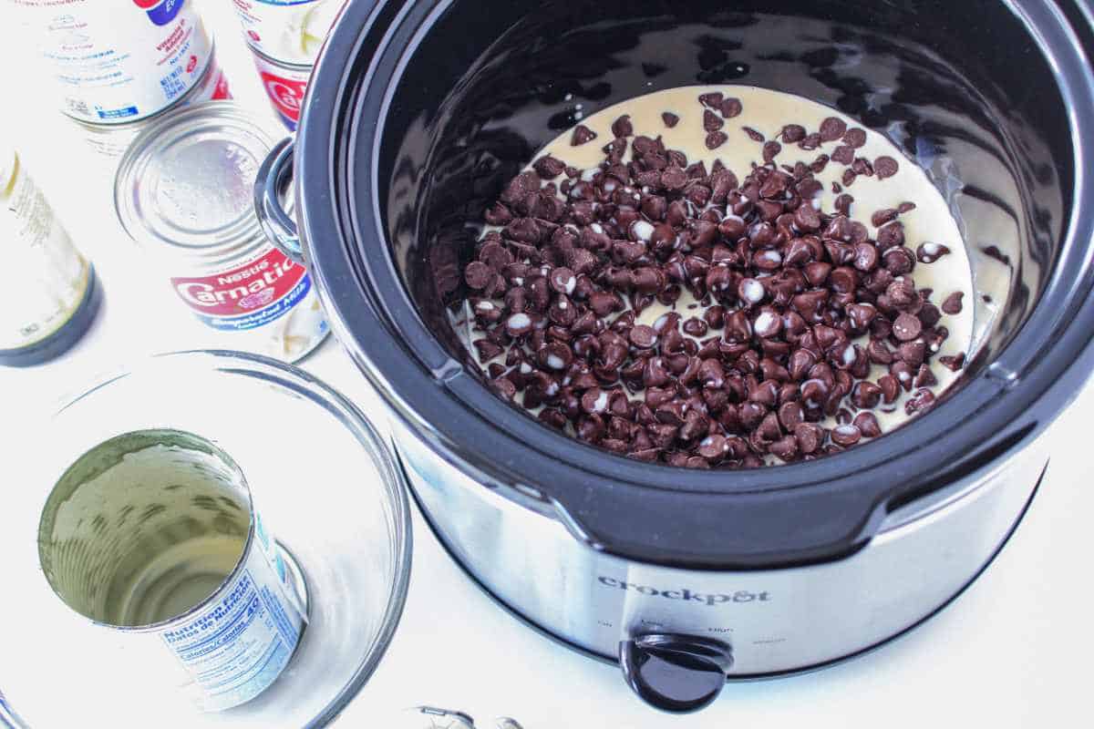 milk added to slow cooker with chocolate chips.