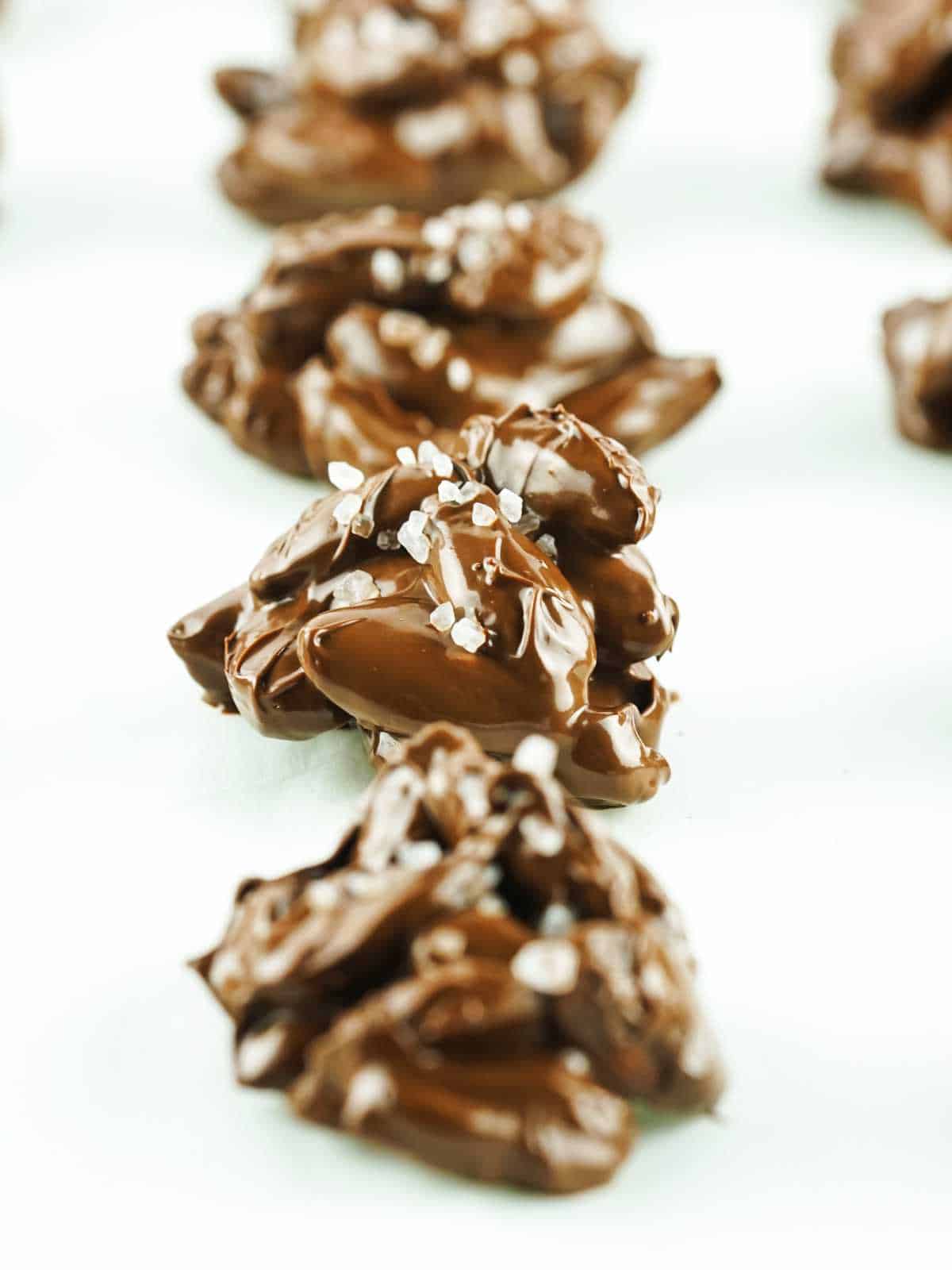 rows of chocolate candies firming up on parchment paper.