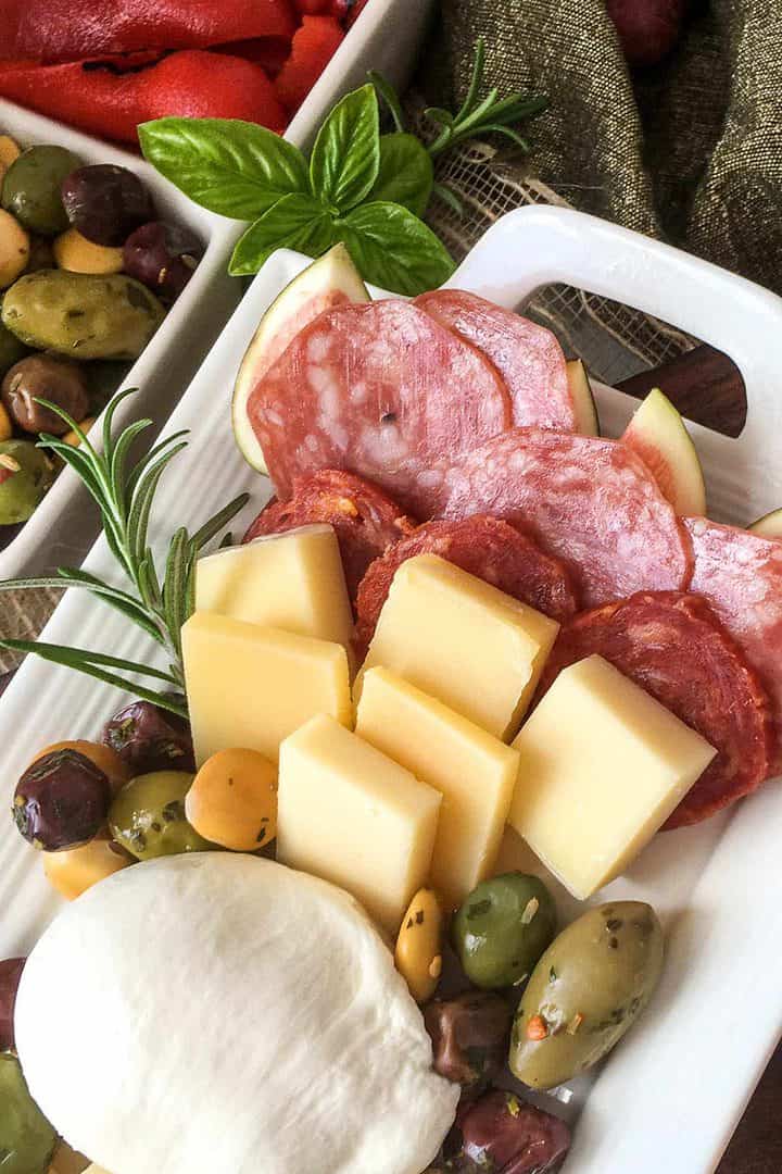 arranged cheeses and cured meats on a charcuterie platter.