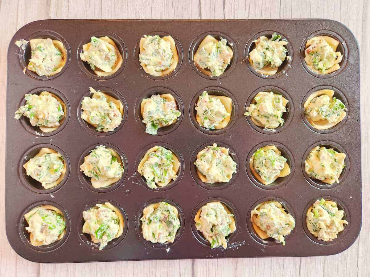 spinach and cheese filling added to puff pastry in the muffin tin.