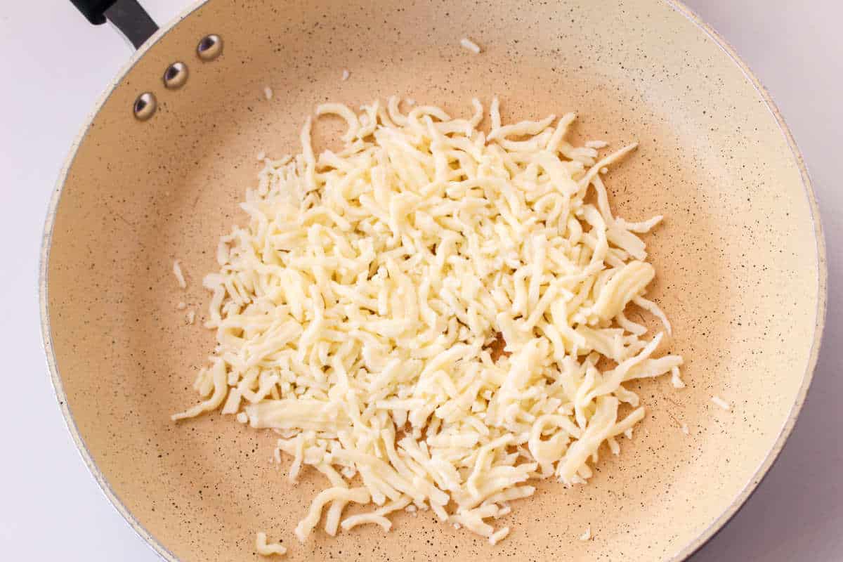 mozzarella cheese browning in a skillet.