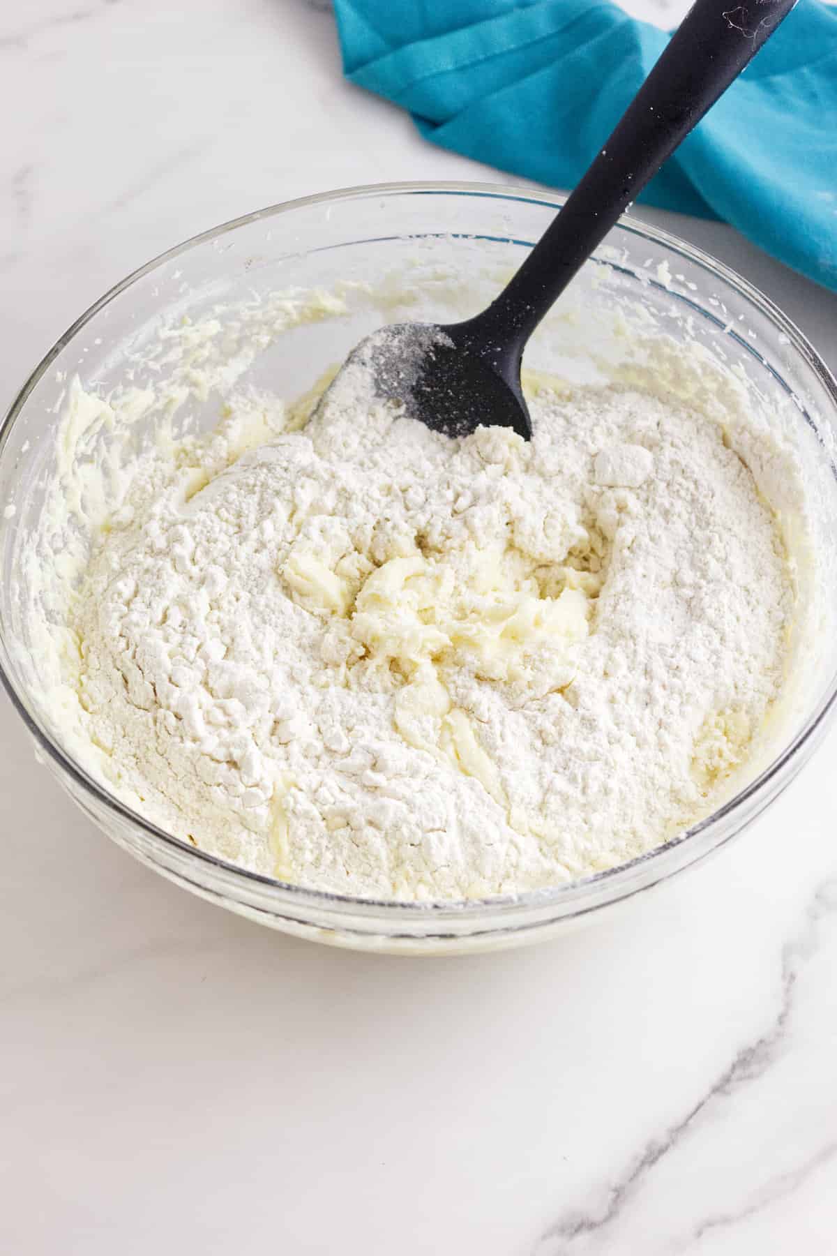 mixing bowl with creamed sugar and butter mixed with flour ingredients.