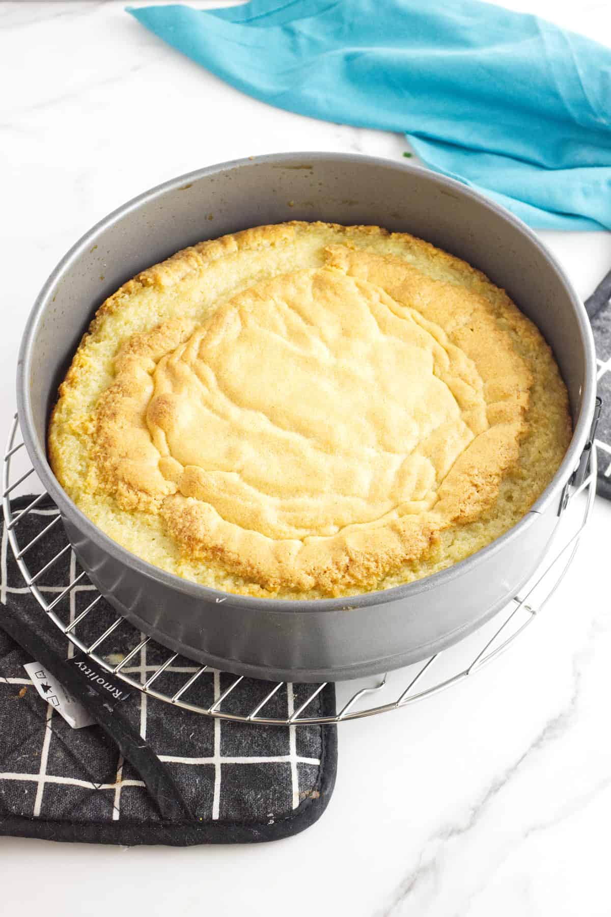 baked cake in a pan cooling on a rack.