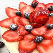 cheesecake with sliced strawberries on top as decoration.