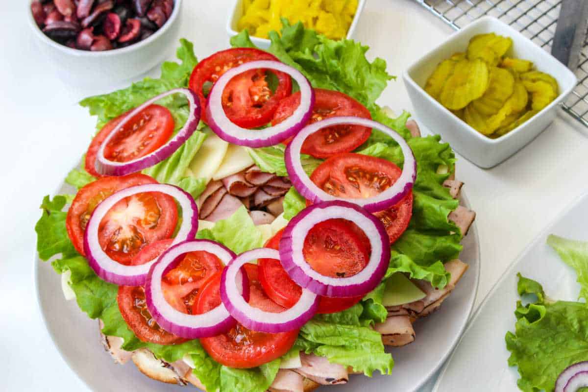 lettuce, tomatoes, and onion on a sandwich.