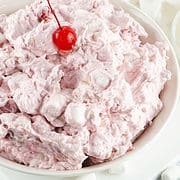 cherry fluff in a bowl, garnished with a maraschino cherry.