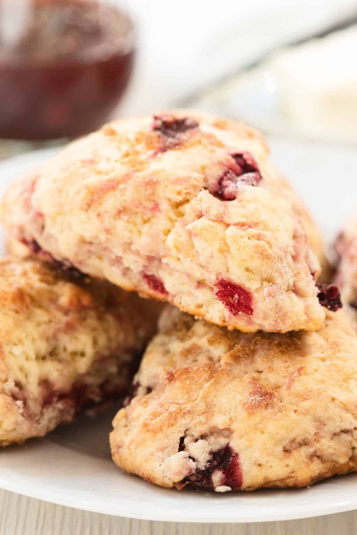 cream scones with cherries, served with butter and preserves.