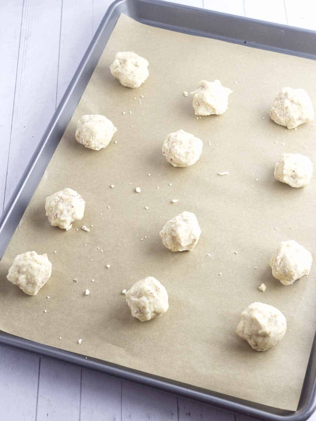 cookie balls on a baking sheet ready to bake.