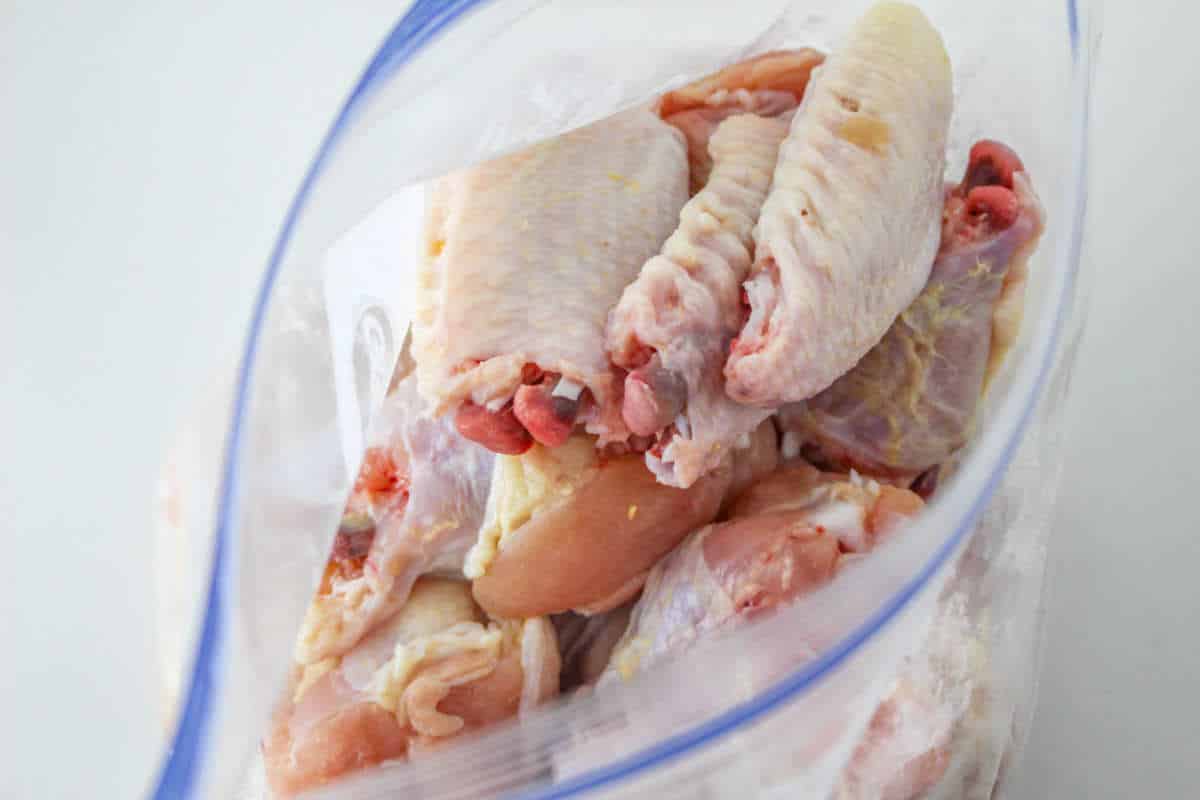 raw chicken in bag with seasonings.