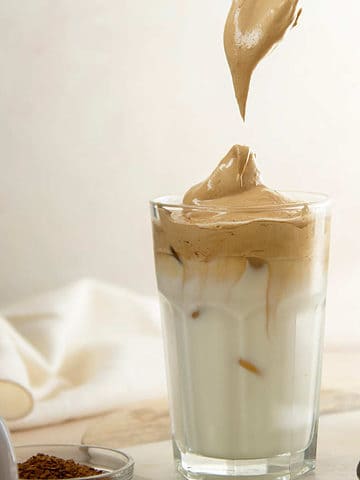 Iced dalgona coffee with coffee foam on top.