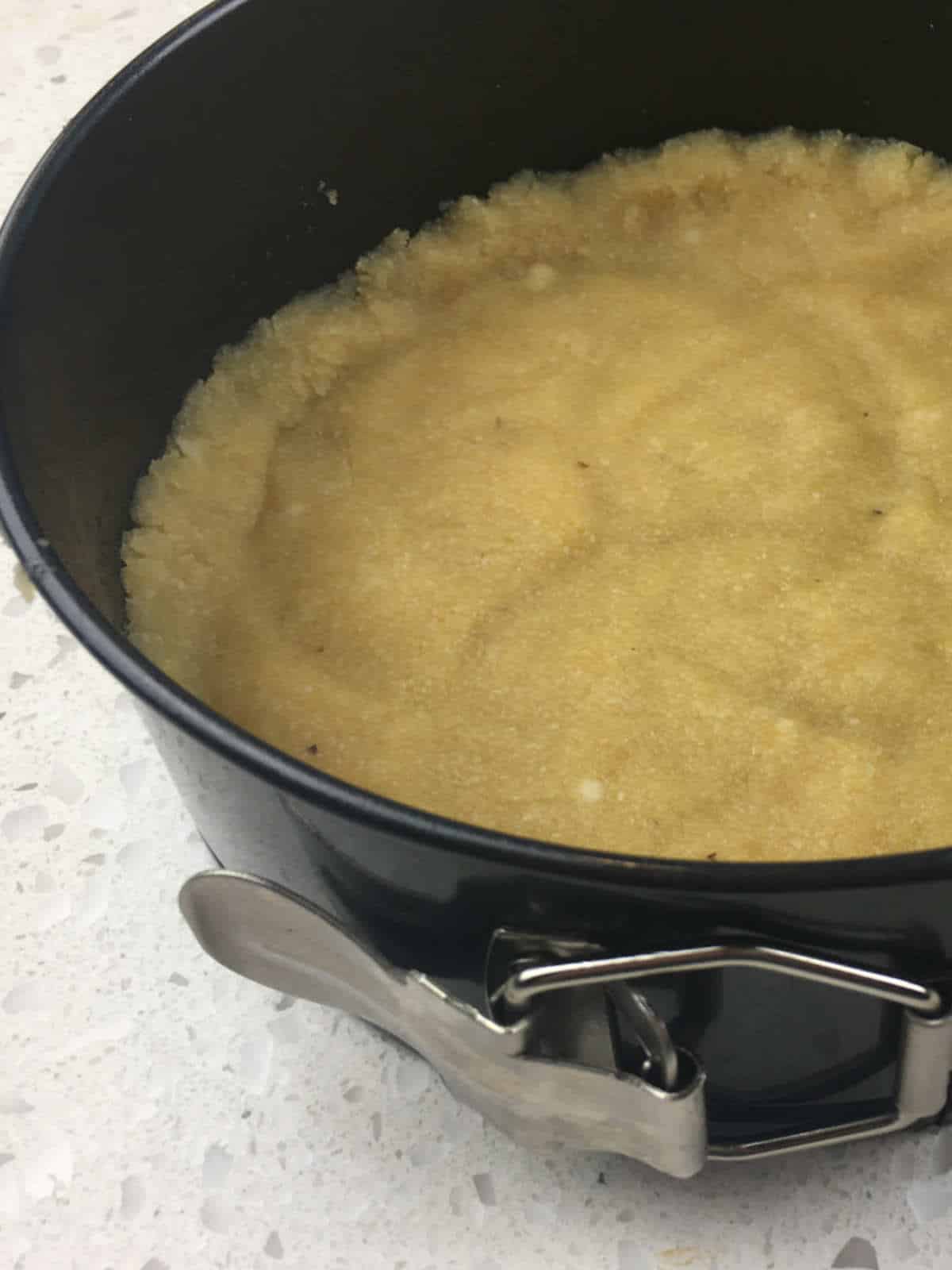 shaping keto cheesecake crust in a Springform pan.