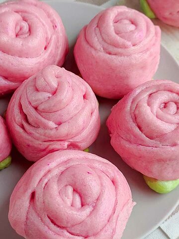 Pink steamed mantou buns shaped like rose buds.