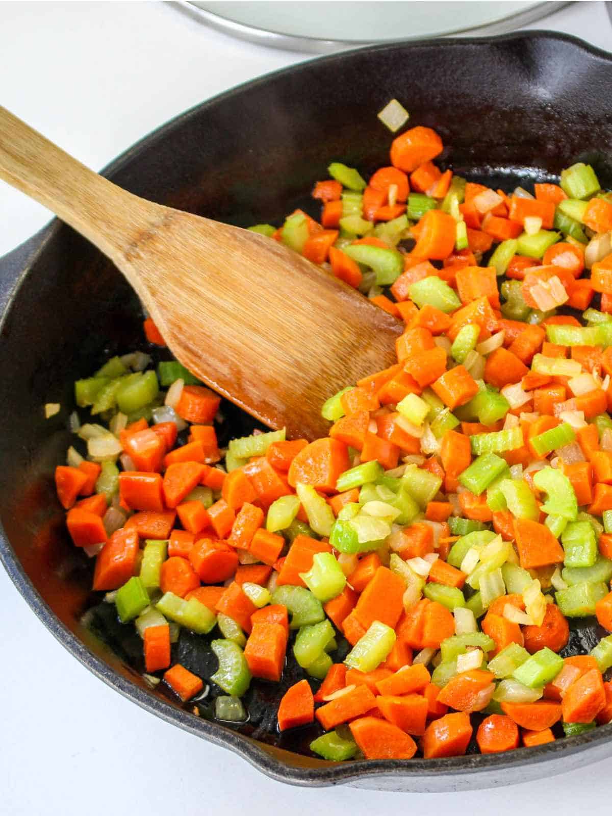 sauteing carrots, onion, and celery in a cast iron skillet.