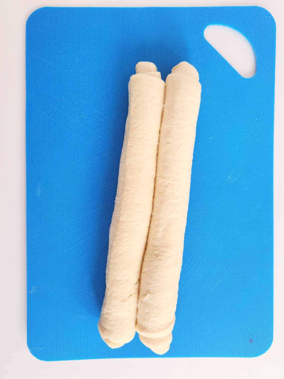 dough rolled up to the center from both ends.