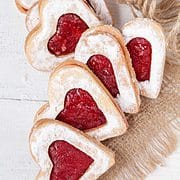 Valentines Day raspberry linzer cookies on a piece of cloth for gift giving.